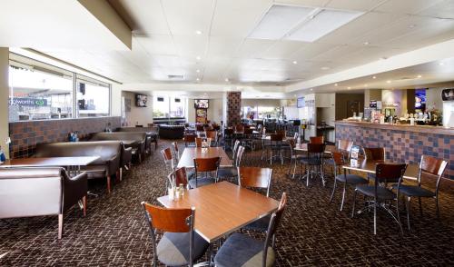 a restaurant with tables and chairs and a bar at Prince of Wales Hotel in Brisbane