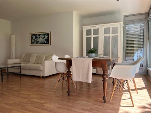 uma sala de estar com uma mesa de madeira e cadeiras brancas em Villa Maria em Rabla