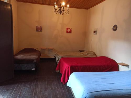 a room with three beds and a chandelier at Casa Seibel in Quetzaltenango