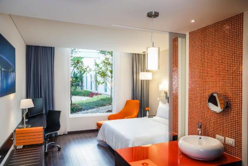 a hotel room with a bed and a desk and a sink at Fiesta Inn Plaza Central Aeropuerto in Mexico City