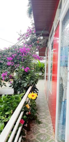 a balcony with flowers on the side of a building at Mr.Khanh Coffee in Xuân Trường