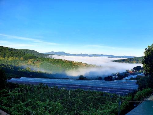 un grupo de vagones de tren en un valle con nubes en Mr.Khanh Coffee, en Xuân Trường