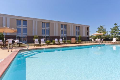 een groot zwembad met stoelen en een gebouw bij Holiday Inn Express Woodstock-Shenandoah Valley, an IHG Hotel in Woodstock