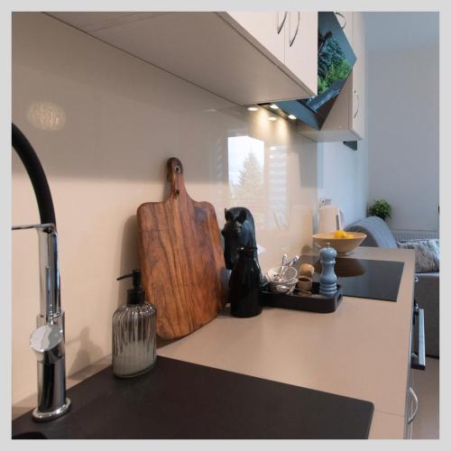 a kitchen counter with a wooden cutting board on it at Apartamenty na Tatarskiej in Przemyśl