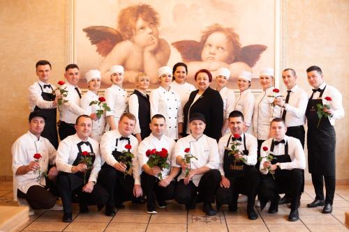 a group of chefs posing for a picture in front of a painting at Nadiya Hotel in Ivano-Frankivsʼk