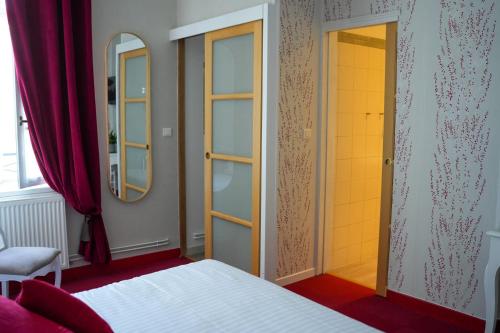 a bedroom with a bed and two mirrors at Hôtel Picardia in Saint-Valery-sur-Somme
