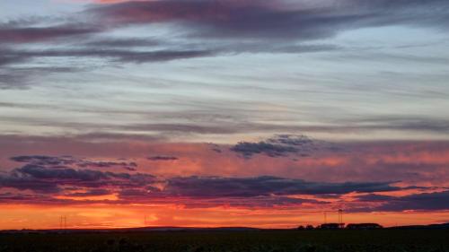 a cloudy sky with a sunset in a field at HT Apartman in Mezőkövesd