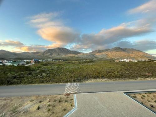 a view of a road with mountains in the background at Escape to Pringle in Pringle Bay