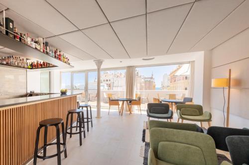 un restaurant avec un bar doté de chaises et de tables dans l'établissement Eurostars Pórtico Alicante, à Alicante
