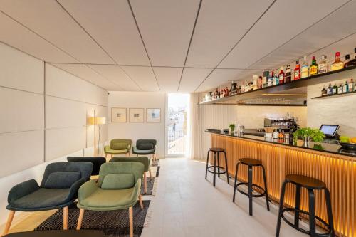 a bar with green chairs and a counter at Eurostars Pórtico Alicante in Alicante