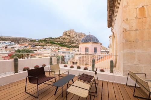 a balcony with chairs and a view of a city at Eurostars Pórtico Alicante in Alicante