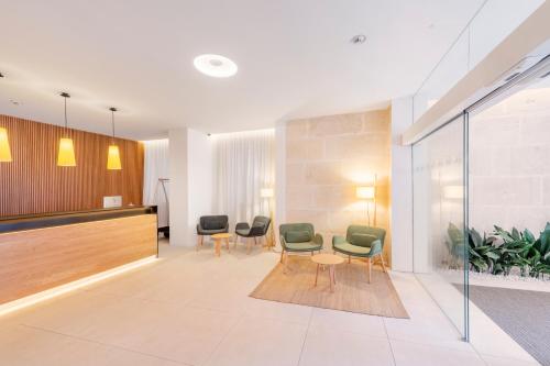 a waiting area with chairs and a table in a lobby at Eurostars Pórtico Alicante in Alicante