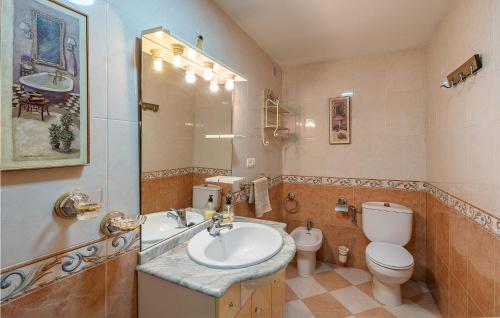 W łazience znajduje się umywalka, toaleta i lustro. w obiekcie 5 Bedroom Awesome Home In Trasmulas, Granada w mieście Trasmulas
