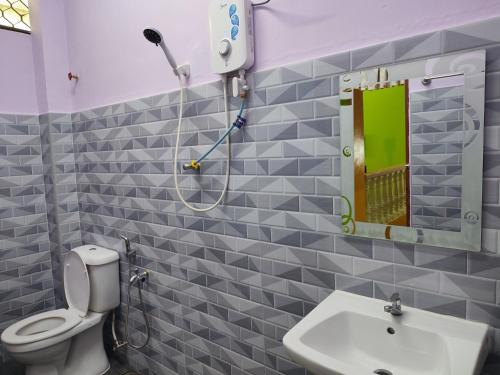 a bathroom with a toilet and a sink and a mirror at KLUANG BARAT HOMESTAY in Kluang