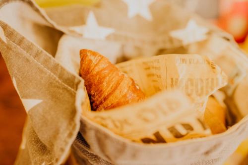a basket of croissants and oranges in a wrapper at Das Hotel Stern, B&B KG - digital & contactless check-in in Sankt Gilgen
