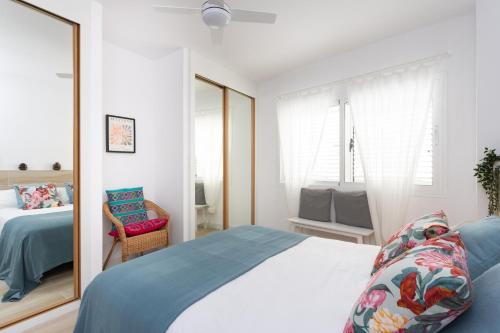 Schlafzimmer mit einem Bett und einem Spiegel in der Unterkunft Home2Book Stylish Apartment Alcalá Beach in Alcalá