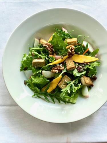 a salad in a white bowl on a table at Firefly Estate Bequia in Crescent Beach