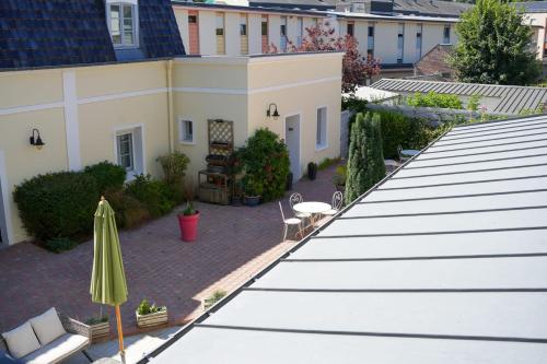 an overhead view of a patio with an umbrella and a building at Hôtel Picardia in Saint-Valery-sur-Somme