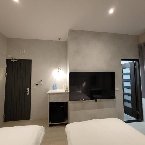 a bedroom with a large flat screen tv on the wall at 芙蘿拉萃旅 in Taitung City