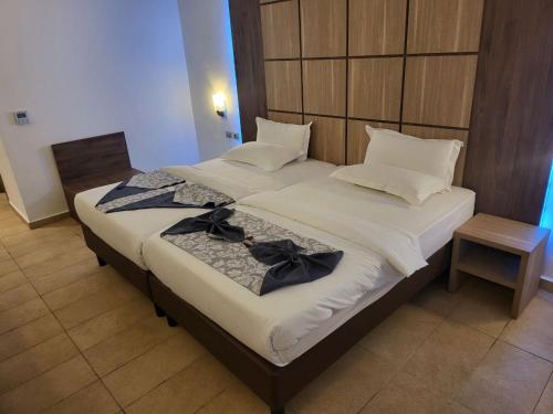 a large bed with two bow ties on it at Hotel Franco Yaounde in Yaoundé