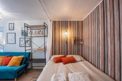 Un dormitorio con una cama y un sofá azul. en L'Alexandrin, en Charleville-Mézières