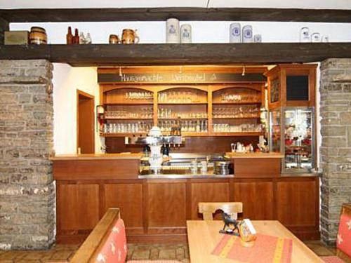 a bar in a restaurant with a counter and a table at Hotel Brunneck in Schönau am Königssee