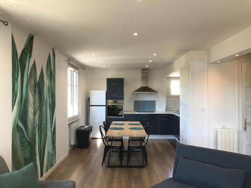 une cuisine et une salle à manger avec une table et des chaises dans l'établissement Un petit bout de rêve, balcon, parking & proche centre, à Annecy