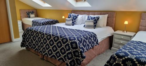 a bedroom with two beds with blue and white sheets at LLety Cynin in Llangynin