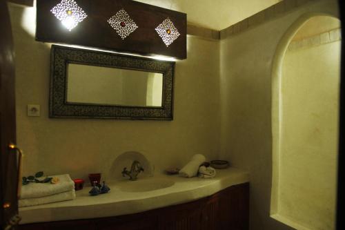 y baño con lavabo y espejo. en Riad Azenzer, en Marrakech