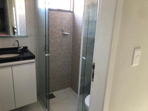 W łazience znajduje się szklana kabina prysznicowa i umywalka. w obiekcie Diversão, férias, casa na praia de cumbuco. w mieście Caucaia