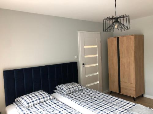 una camera con due letti e un lampadario a braccio di Apartament 15G a Skawina