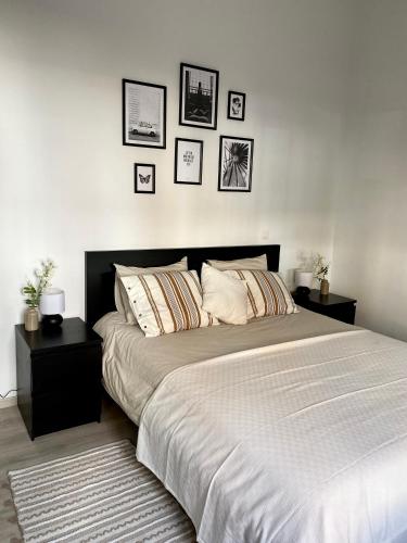 a bedroom with a large bed with four pictures on the wall at Superbe logement près de Bruxelles avec spa privé in Brussels