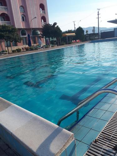 a swimming pool with blue water in front of a building at Hotel Meteor in Shkodër