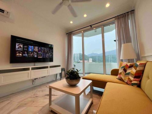 sala de estar con sofá y TV en Tanjung Bungah PEARL HILL42 Homestay, en Tanjung Bungah