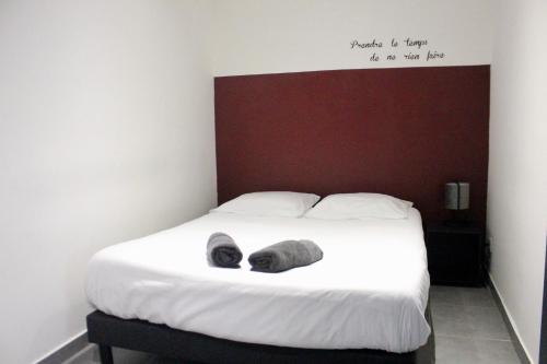 - une chambre avec un lit et un panneau mural dans l'établissement La petite maison by PÓM, à Lorient