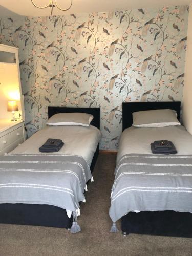 two beds sitting next to each other in a bedroom at Sweet Caroline at Longton. Great location for Stoke on Trent, The Potteries and Alton Towers. in Longton