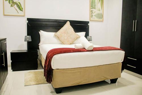 a bedroom with a bed with a black headboard at Pitikwe Hill Guesthouse in Lobatse