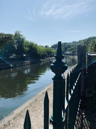 a fence next to a river next to a bridge at Maison Henri Namur in Namur
