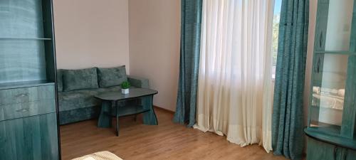 een woonkamer met een bank en een tafel naast een raam bij VIP Apartments in the Centre in Mukacheve