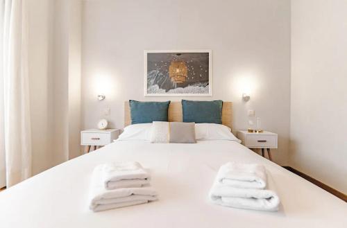 ein Schlafzimmer mit einem großen weißen Bett mit Handtüchern darauf in der Unterkunft BRIGHT FLAT Parking/Wanda Metropolitano/Airport in Madrid