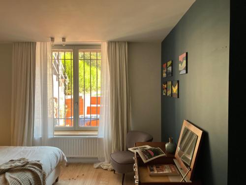 a bedroom with a bed and a window at Maison Henri Namur in Namur