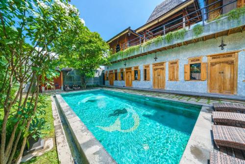 a swimming pool in front of a building at Black Pearl Hostel in Canggu
