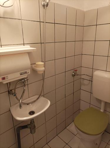 a bathroom with a green toilet and a sink at Къща за гости Бяла Къща in Kavarna