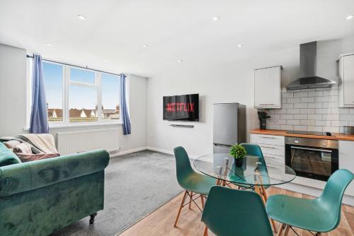 a living room with a glass table and green chairs at Cosy 2 Bed- Gillingham in Gillingham