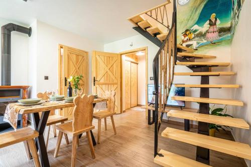 a dining room with a wooden table and a spiral staircase at CIZANHOUSE in Zakopane