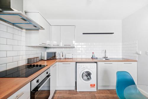 a white kitchen with a washing machine in it at Cosy 2 Bed- Gillingham in Gillingham