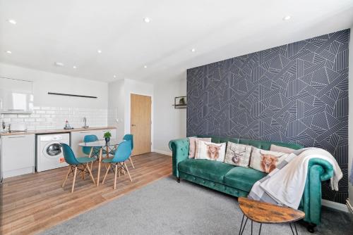 a living room with a green couch and a table at Cosy 2 Bed- Gillingham in Gillingham