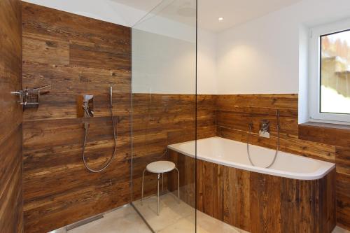 a bathroom with a tub and a glass shower at Ferienwohnung Adlerhügel in Ruhpolding
