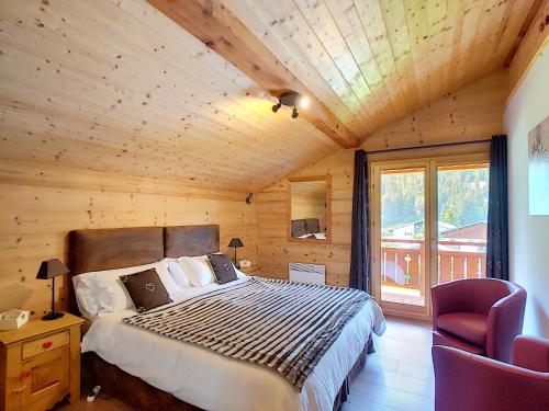 - une chambre avec un lit dans une cabane en bois dans l'établissement Chalet CLEMALOU 14-16 personnes avec jacuzzi, à Châtel