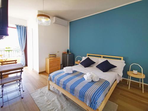 1 dormitorio con 1 cama con pared azul en Pasitea, en Bagheria